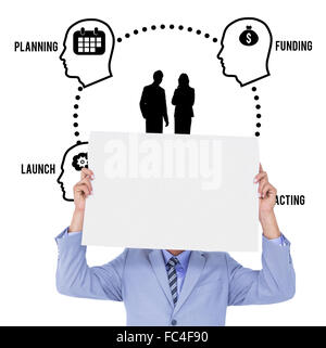 Composite image of  portrait of a businessman hiding his face behind a blank panel Stock Photo