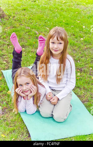 Two girls sitting on grass Stock Photo