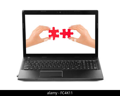 Hands and puzzle in computer notebook Stock Photo
