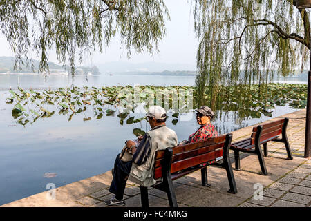 Chinese couple enjoys the beauty of West Lake, a freshwater lake in Hangzhou, the capital of Zhejiang province in eastern China. Stock Photo