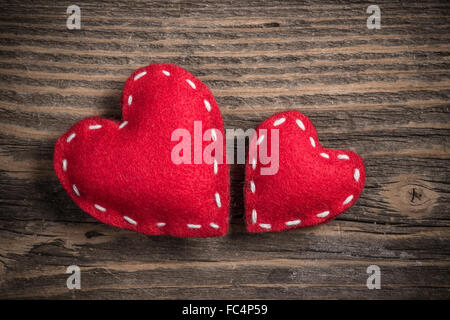 Two red felt hearts on old wooden background Stock Photo