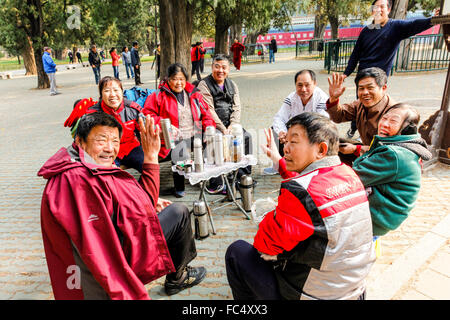 CHINA,Chinese  scene of a busy park at The Temple of Heaven in Beijing with Chinese men drinking tea at sidewalk tables Stock Photo