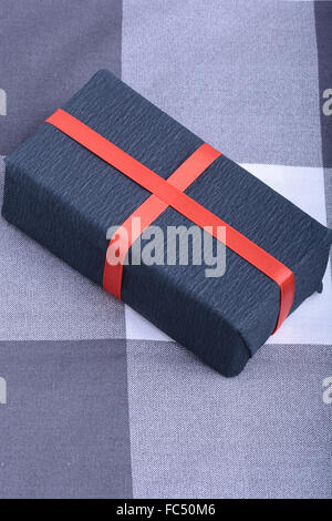 The red square box is tied with a black ribbon. Gift, top view ...