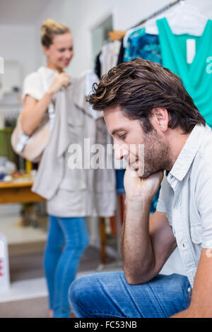 Bored man sitting in front of his girlfriend Stock Photo