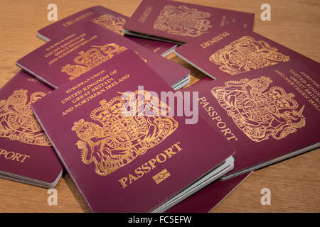 UK passports piled on a wooden desk. Stock Photo