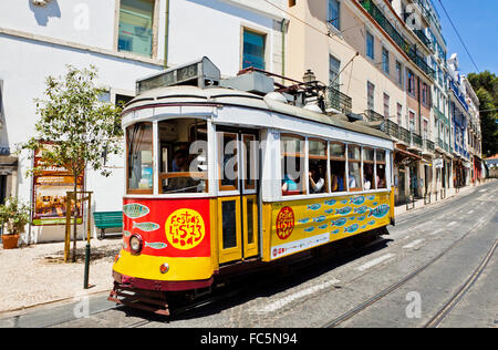 Traditional vintage Lisbon yellow tram decorated with sardines during Popular Saints Festival (Festas dos Santos Populare) Stock Photo