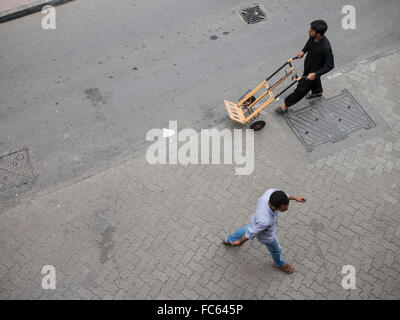 Dubai Souk: Man pulling a cart to transport goods. Stock Photo