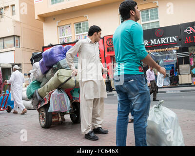 Dubai Souk: Man pulling a cart to transport goods. Stock Photo