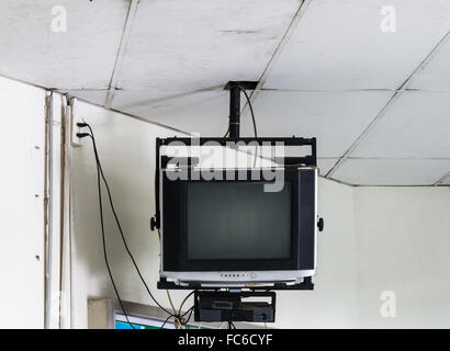 Old television set is hanging on the office building. Stock Photo