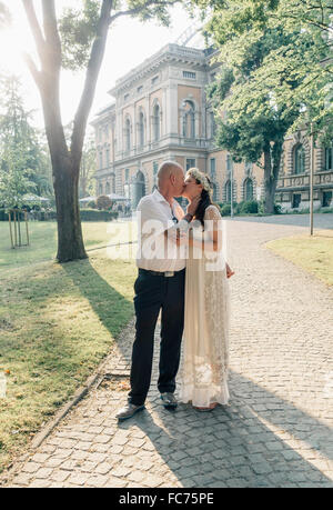 Caucasian newlywed couple kissing outdoors Stock Photo