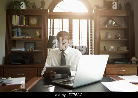 Black doctor using digital tablet in office Stock Photo