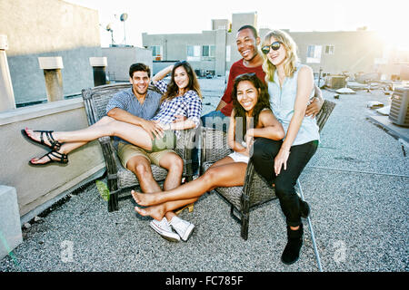 Friends relaxing on urban rooftop Stock Photo