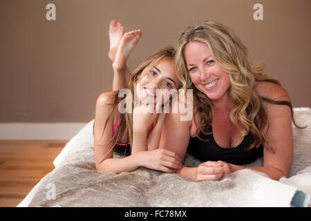 Mother and daughter laying on bed Stock Photo