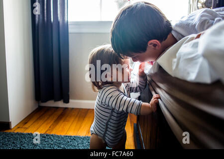 Brother and sister laughing on bed Stock Photo