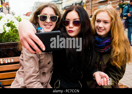 Caucasian women taking selfie on bench Stock Photo