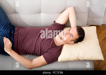Young man lying on the sofa Stock Photo