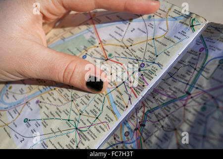 Close up of hand holding Paris city map, Paris, Ile-de-France, France Stock Photo