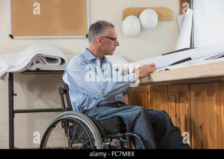 Caucasian architect in wheelchair working in office Stock Photo