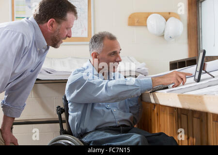 Caucasian architects using digital tablet in office Stock Photo
