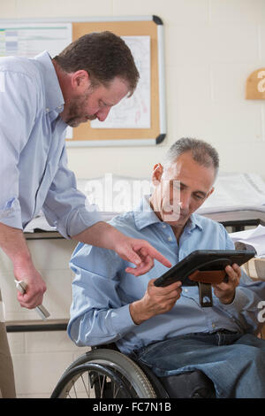 Caucasian architects using digital tablet in office Stock Photo