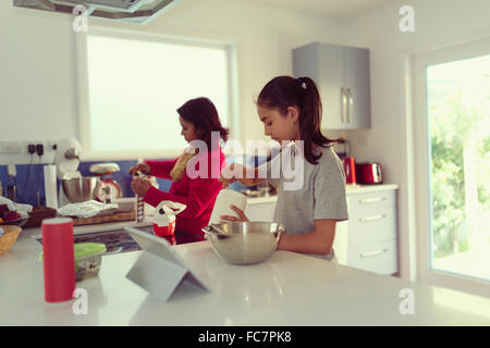 Mother and daughter cooking in kitchen Stock Photo