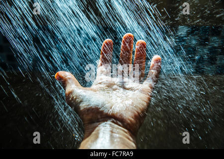 Caucasian man rinsing hand under water Stock Photo