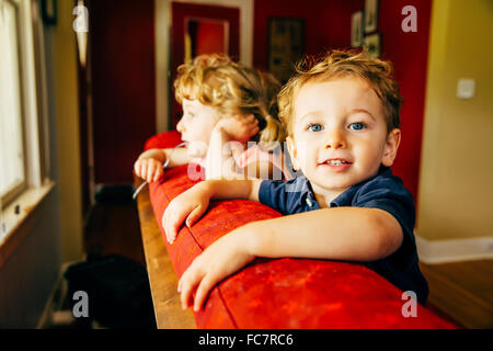 Caucasian children standing on sofa Stock Photo