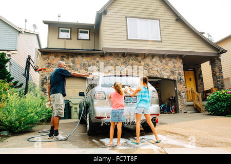 Father and daughters washing car Stock Photo