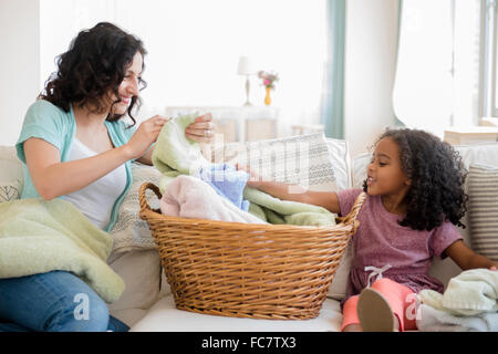 Mother and daughter folding laundry Stock Photo