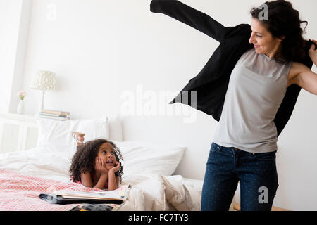Mother and daughter getting ready in bedroom