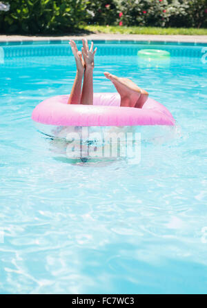 Caucasian woman playing in swimming pool Stock Photo