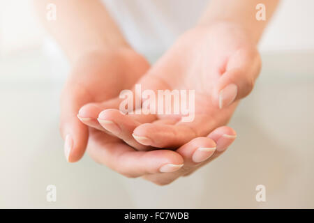 Close up of cupped hands of Hispanic woman Stock Photo