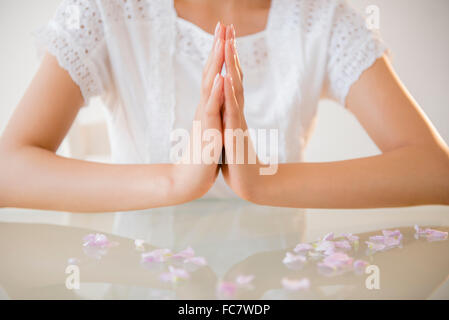 Hispanic woman meditating at table Stock Photo