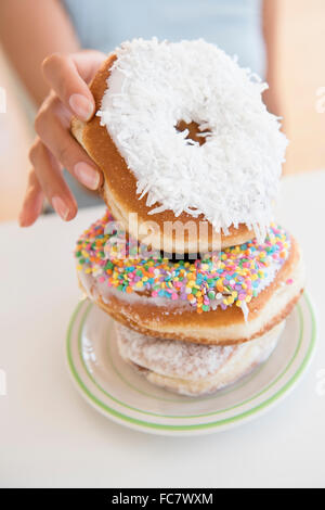 Hispanic woman choosing donut Stock Photo