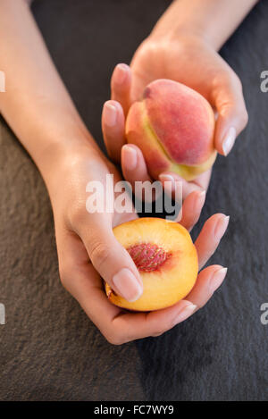 Hispanic woman holding peaches Stock Photo