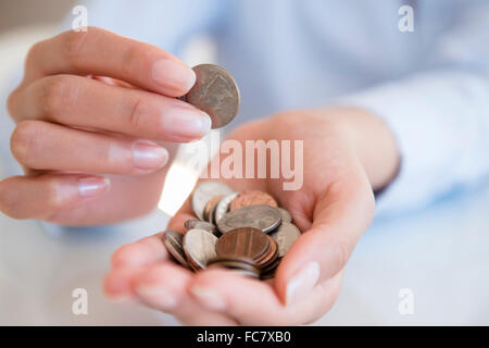 Hispanic woman counting coins Stock Photo