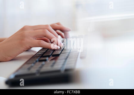 Hispanic businesswoman typing on keyboard Stock Photo