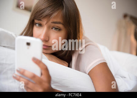 Mixed race woman using cell phone Stock Photo