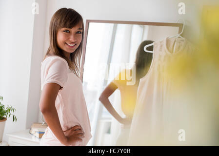 Mixed race woman smiling in front of mirror Stock Photo
