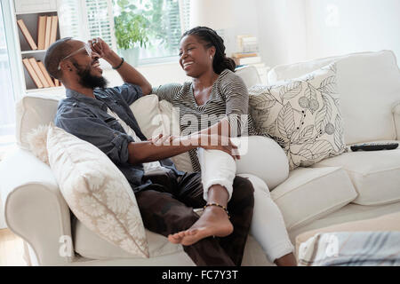 Black couple talking on sofa Stock Photo