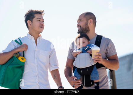 Gay fathers doing errands with baby son Stock Photo