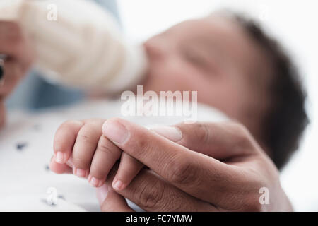 Close up of father holding hand of baby son Stock Photo