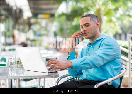 Caucasian businessman talking on cell phone in cafe Stock Photo