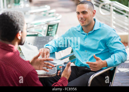 Businessmen talking in cafe Stock Photo