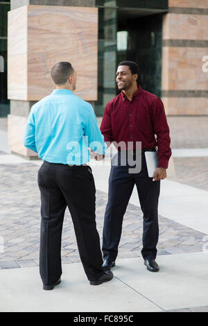 Businessmen shaking hands outdoors Stock Photo