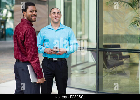 Businessmen smiling outdoors Stock Photo