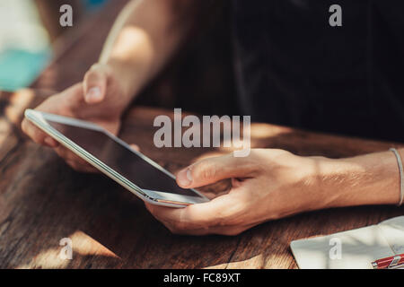 Caucasian man using cell phone at table Stock Photo
