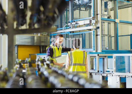 Workers talking in factory Stock Photo