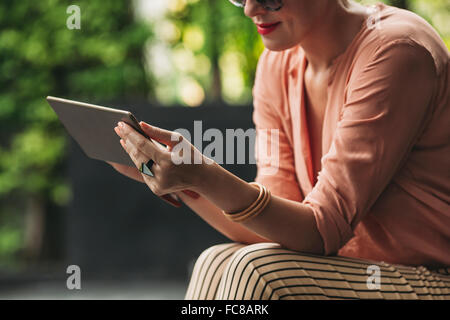 Caucasian woman using digital tablet outdoors Stock Photo