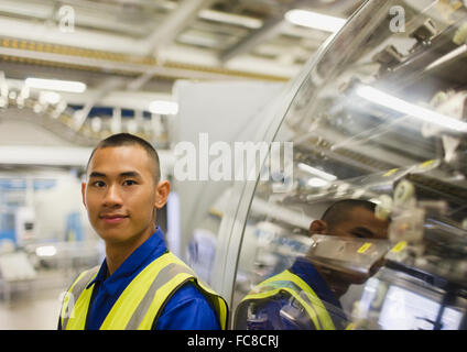 Portrait confident worker leaning on machinery in factory Stock Photo
